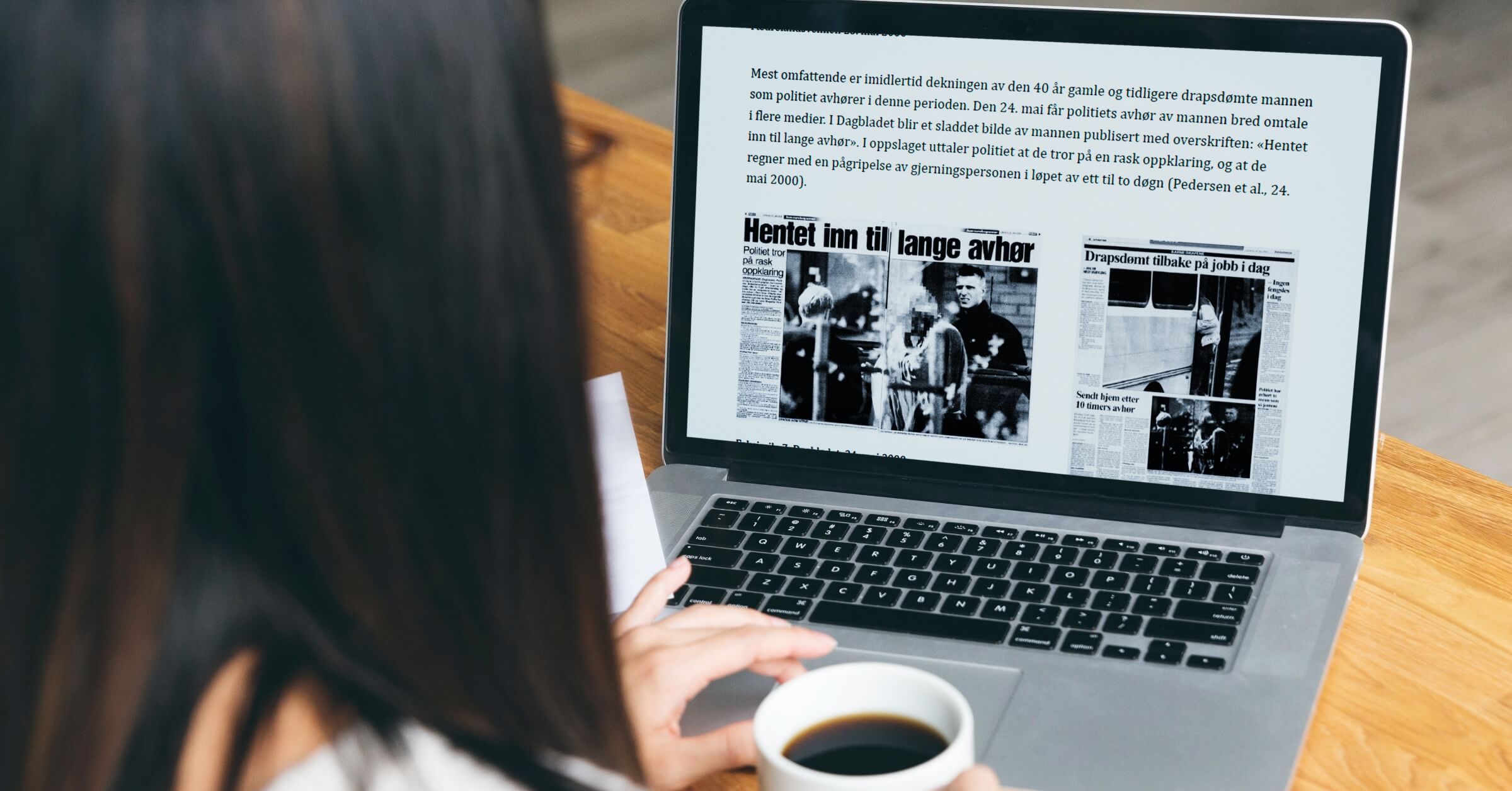 Kvinne scroller i anaylserapporten på sin laptop med en kaffekopp i hånda